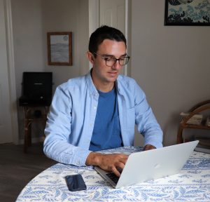 A writer on a white laptop