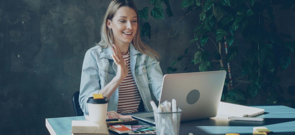 Writer waving at laptop